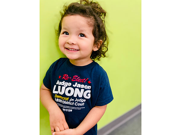 A child wearing a re-elect Jason Luong shirt