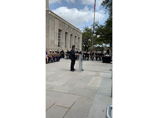 Jason Luong speaking to a crowd outdoors