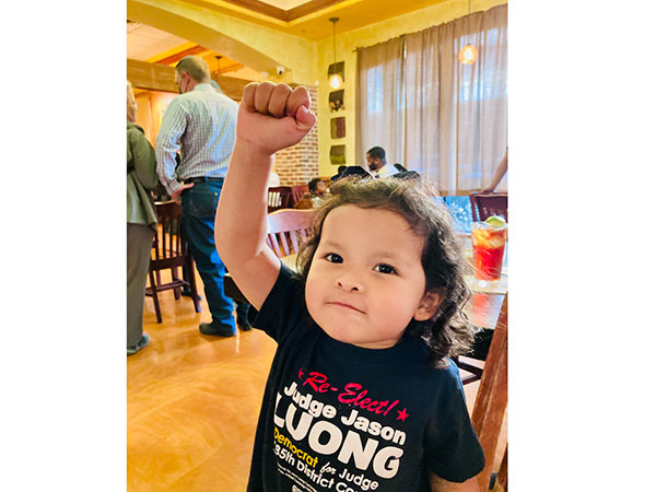 A child wearing a re-elect Jason Luong shirt