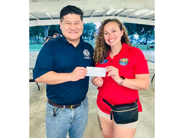 Jason Luong holding a check with a woman